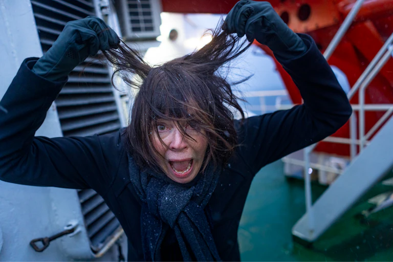 A person making a wild face while pulling her hair straight out from her head.