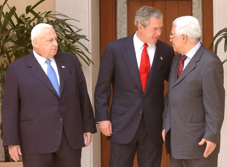 Three men in suits stand around