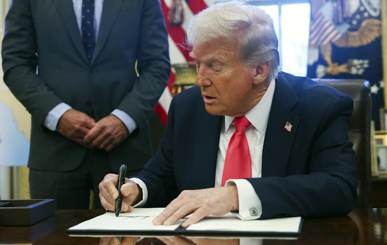 Plástico amenaza los ecosistemas y la salud humana, pero las soluciones basadas en evidencia están bajo fuego político 1 El hombre blanco antiguo en el traje y la corbata roja firma el documento