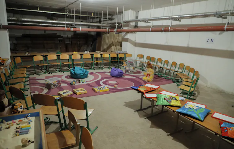 Interior of a makeshift a bomb shelter arranged as a classroom.
