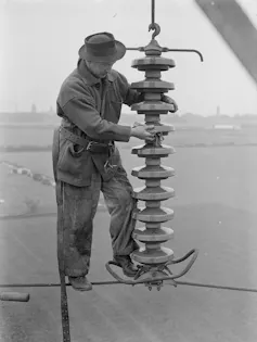 Man stands on wire high above countryside