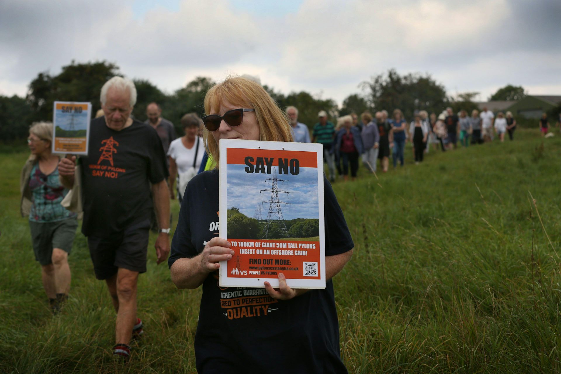 Woman holds 'say no' anti-pylon sign