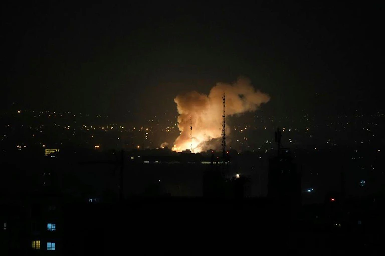 Smoke rises over Tehran at night after Israeli air strikes.