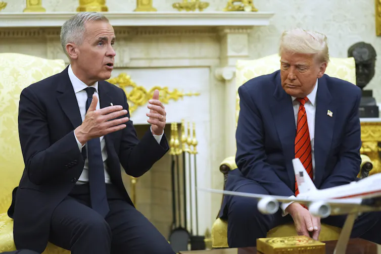 A man with short grey hair answers a question from the media in an ornate office