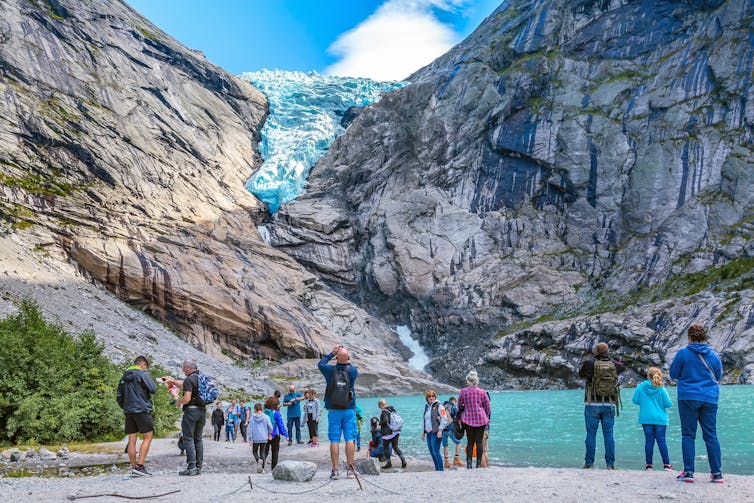 tourists look at receding glacier