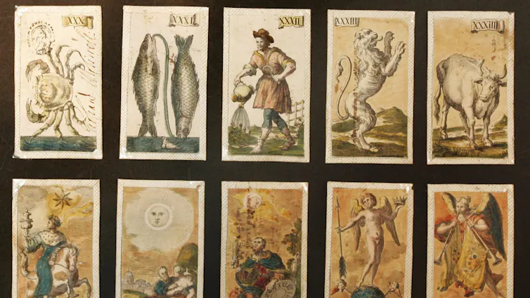 playing cards with various images on them, including a man and two fish