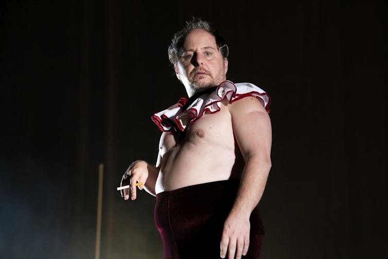 A man, shirtless with a clown ruffle.