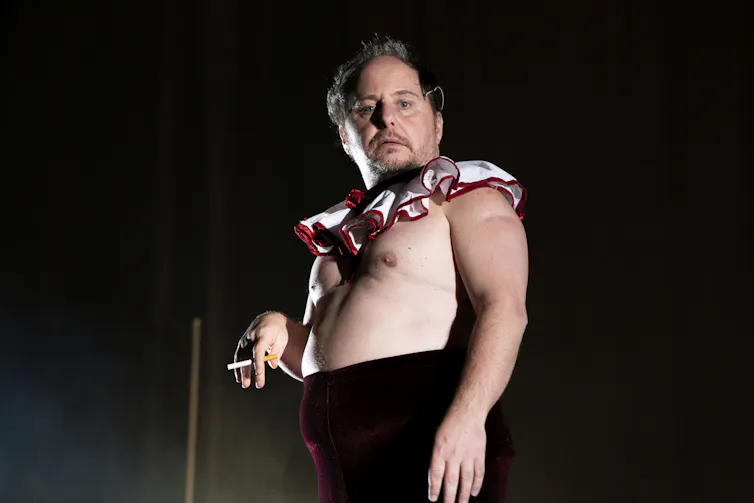 A man, shirtless with a clown ruffle.