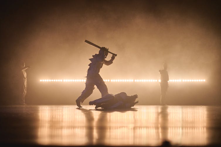 A figure wields a baseball bat above someone on the ground.