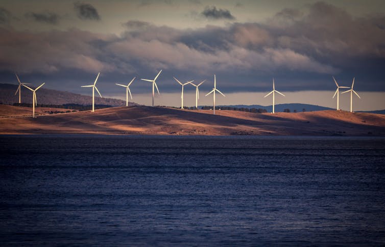 Wind turbines at the edge of a lake.