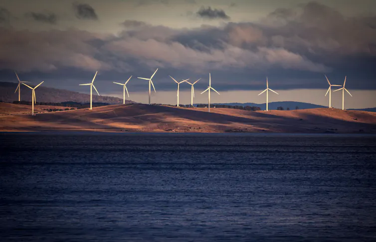 Wind turbines at the edge of a lake.