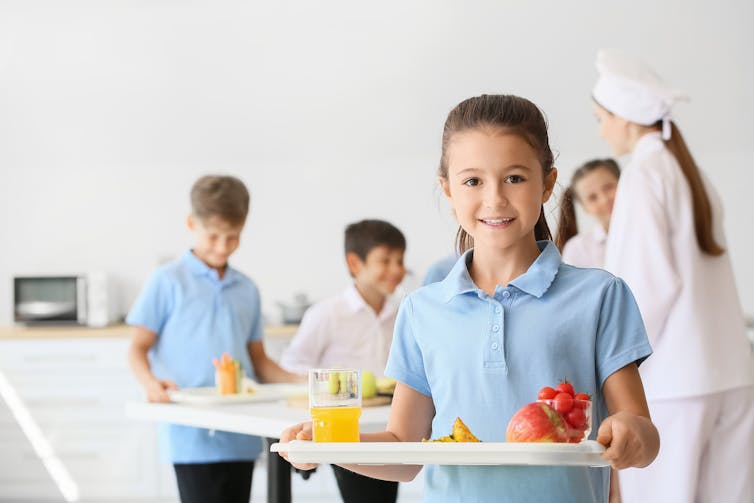 Girl in school uniform with plate of food