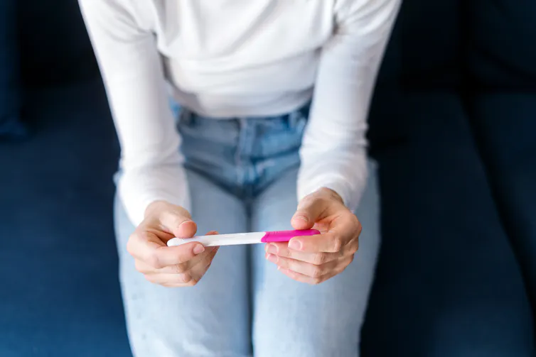 View from above of an anonymous woman holding a pregnancy test