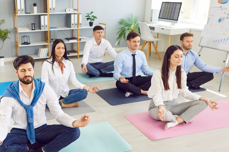 Salariés méditant sur des tapis de yoga.