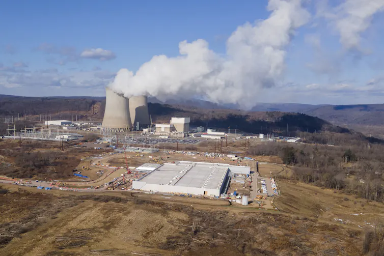A building under construction beside a nuclear power plant