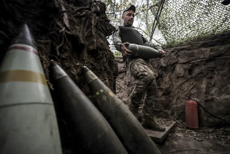 A Ukrainian soldier handles munitions.