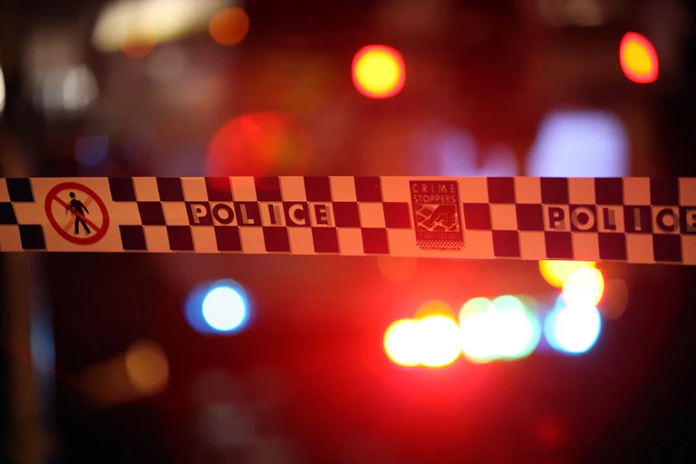 Police tape stretches around a crime scene.