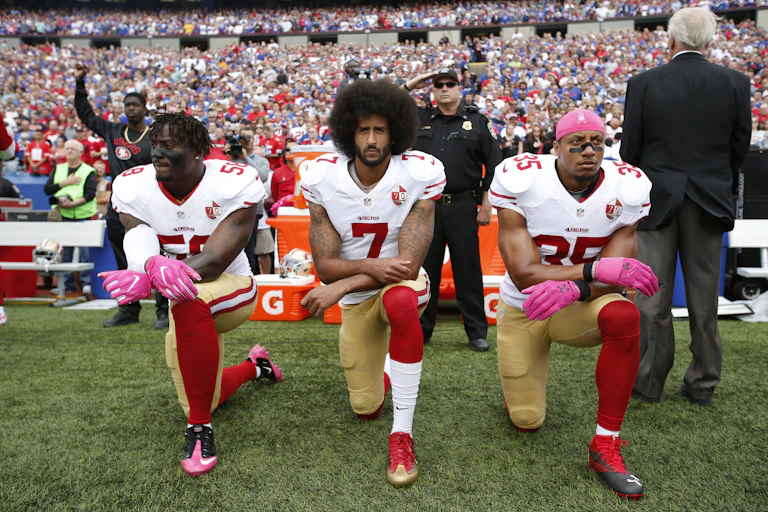 Eli Harold, Colin Kaepernick and Eric Reid of the San Francisco 49ers kneel ahead of a game in 2016.