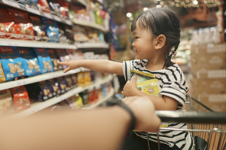 Girl points to packaged foods at supermarket