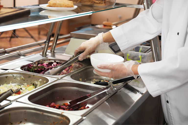 Closeup of wchool canteen worker at serving line.