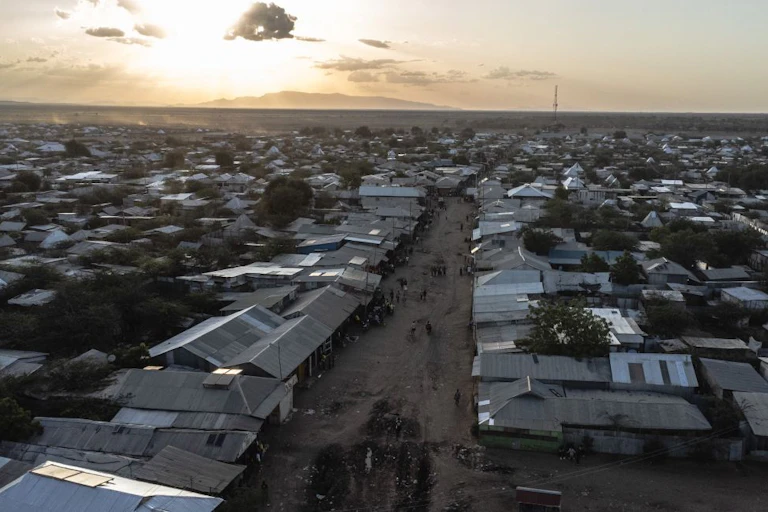 A settlement of tin-roofed houses at sunset.