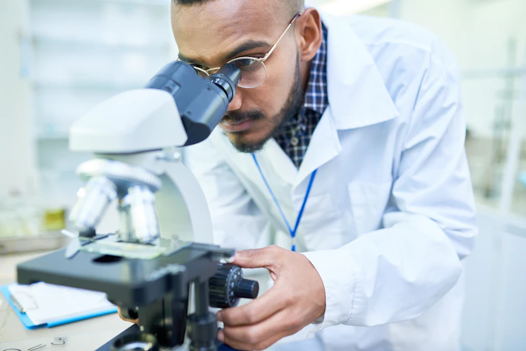 Un scientifique utilise un microscope.