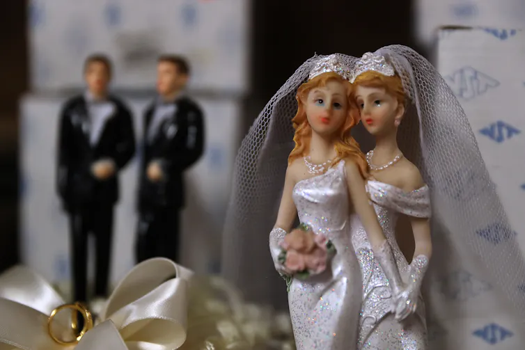 two cake topper brides in the foreground, two grooms in the background