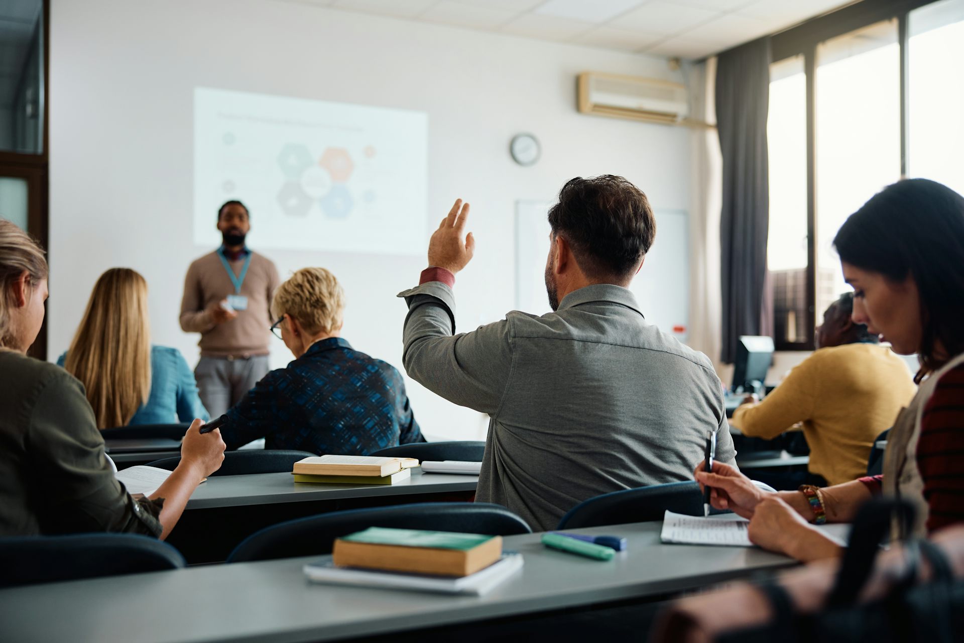 Un jeune homme lève la main dans une classe