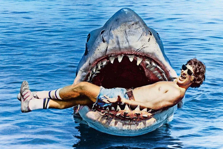 Steven Spielberg poses with the model shark from Jaws