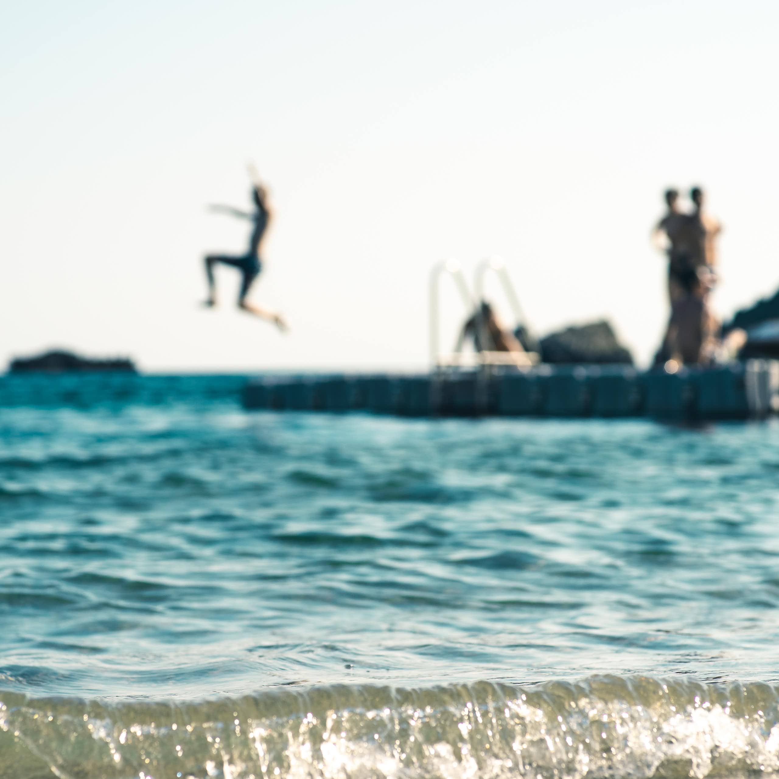 teens jumping into sea