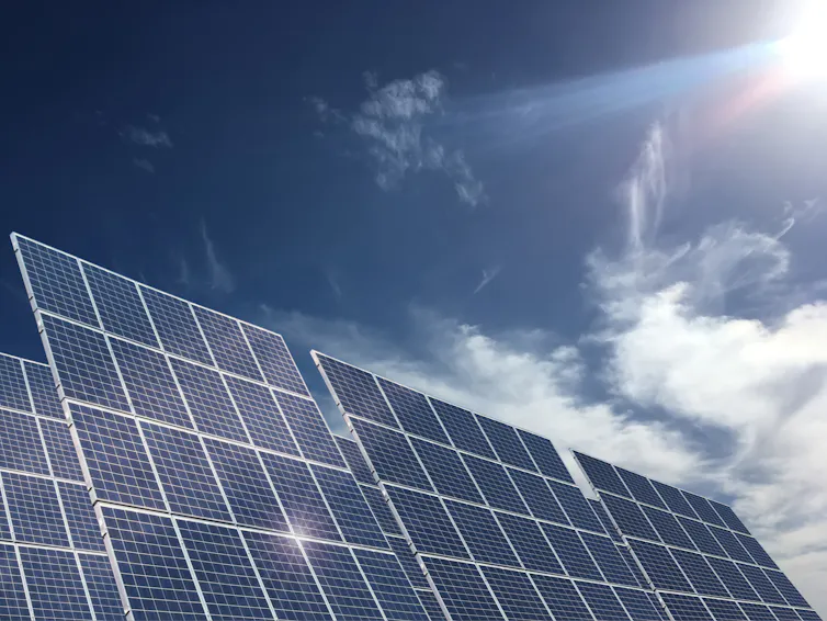 A row of solar panels against a blue sky.