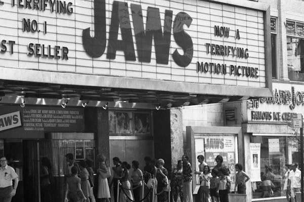 moviegoers lined up under the theater's marquee with 'JAWS' on it