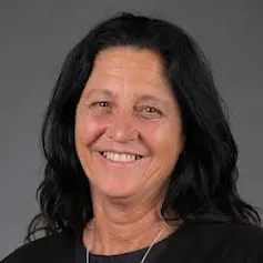 A smiling Christine Couzens wearing a black top
