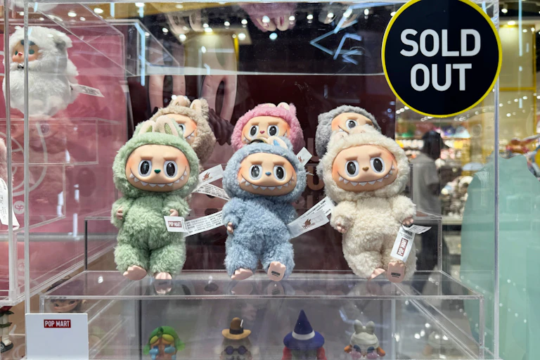 Labubu in a display case with a sold out sticker.