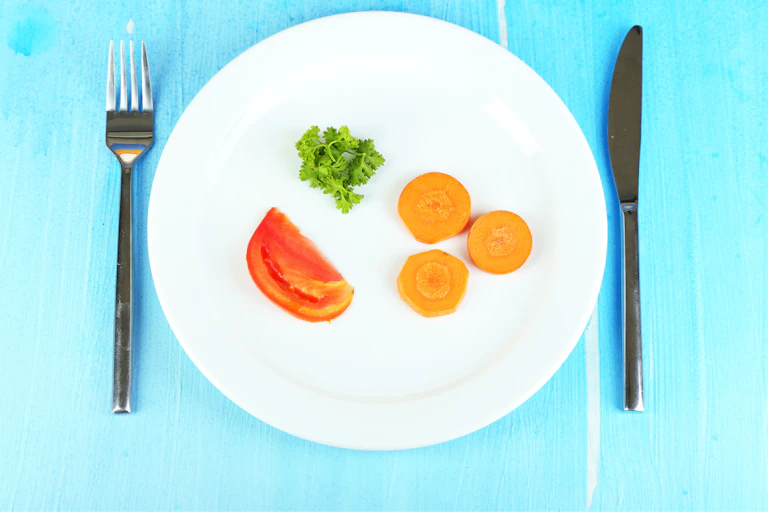 A plate with three tiny portions of veg.