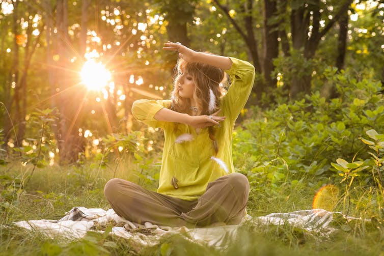 Une femme pratique la méditation dans une forêt