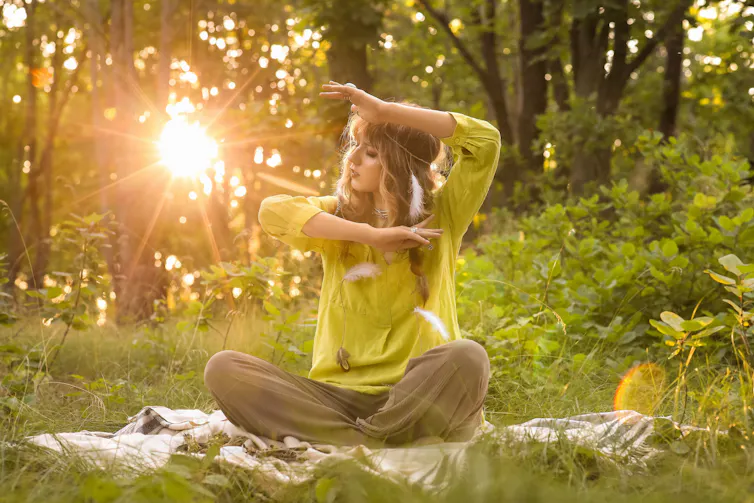 Une femme pratique la méditation dans une forêt
