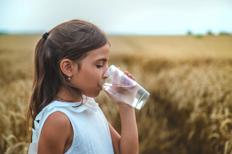 Niña bebiendo un vaso de agua