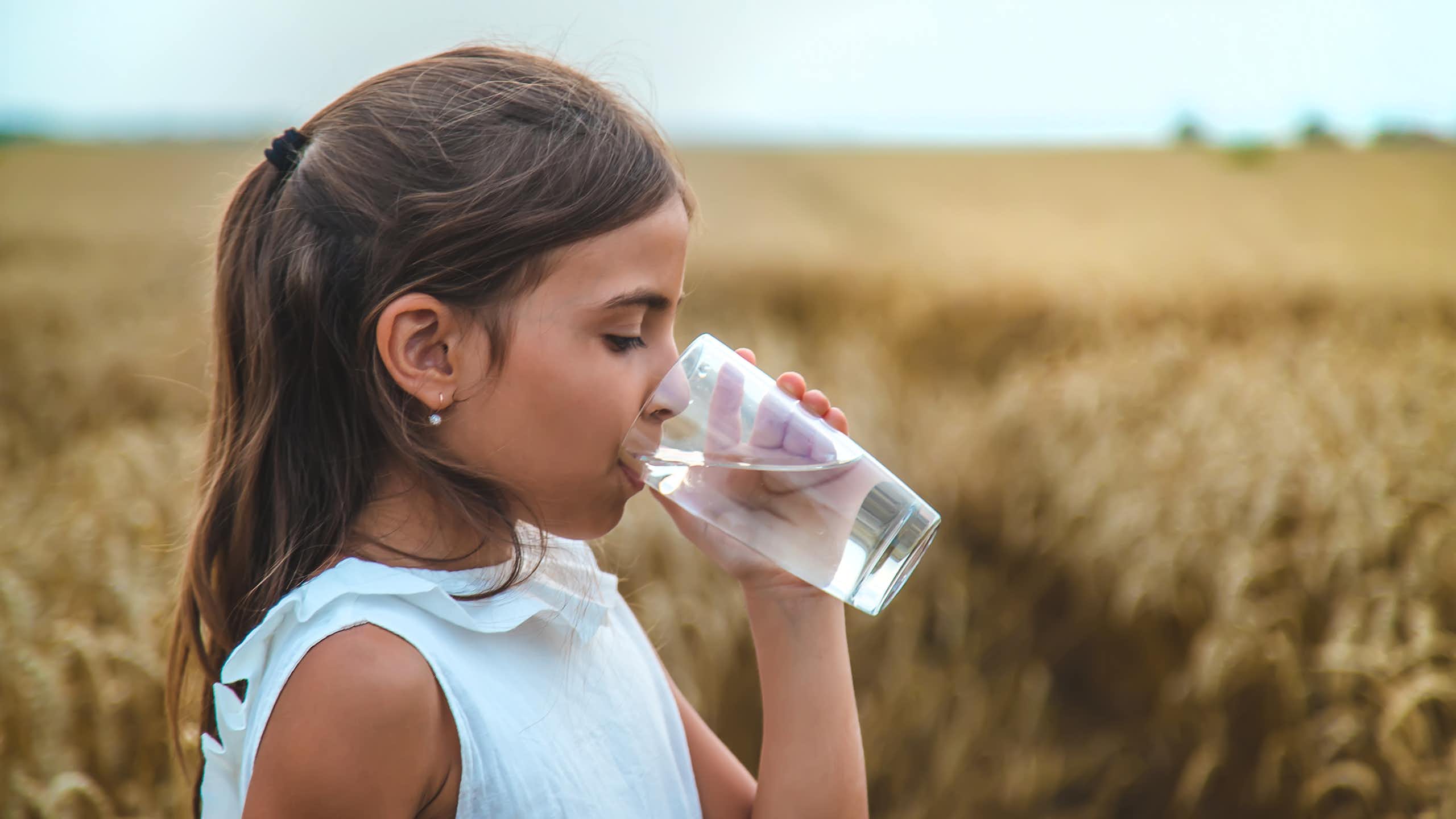 Niña bebiendo un vaso de agua