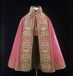 Una capa rosa con el borde decorado.