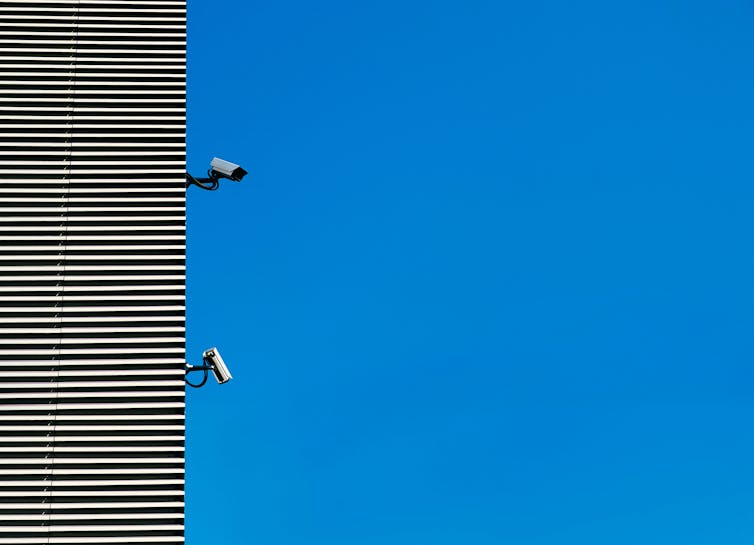 A building with two surveillance cameras.