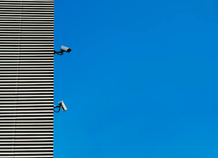 A building with two surveillance cameras.