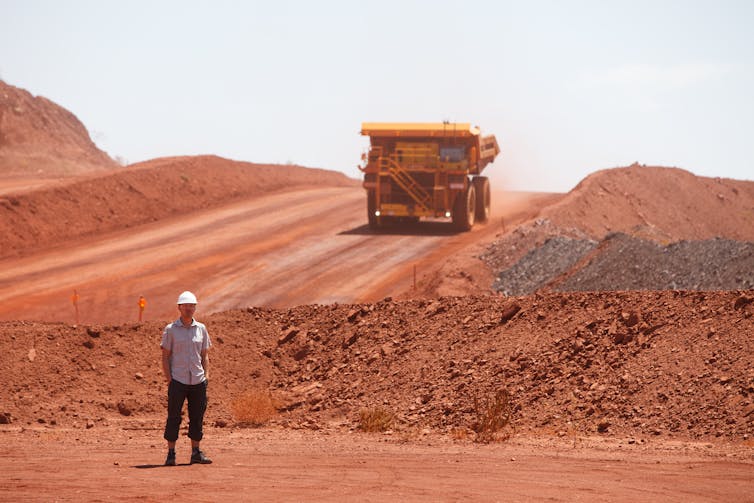 man and mining truck, red earth.