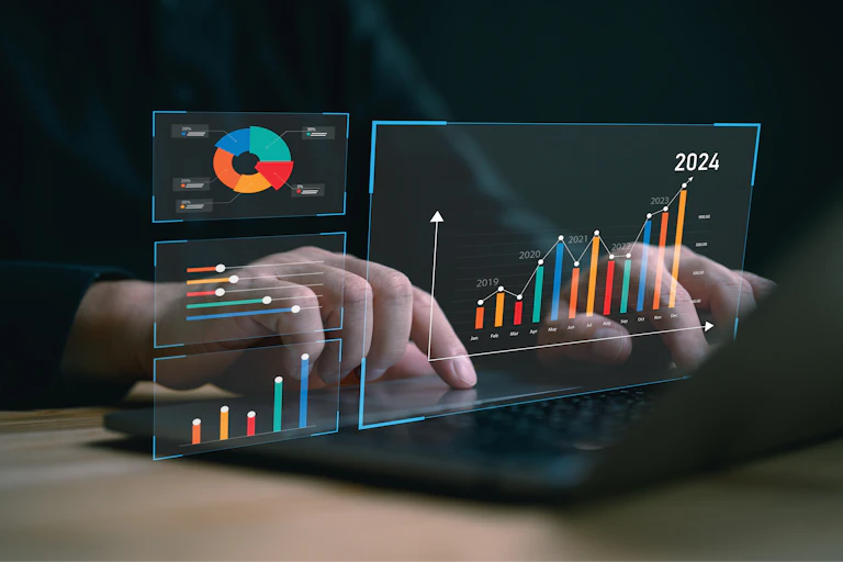Graphiques virtuels en surimprimé sur deux mains qui tapent sur un clavier