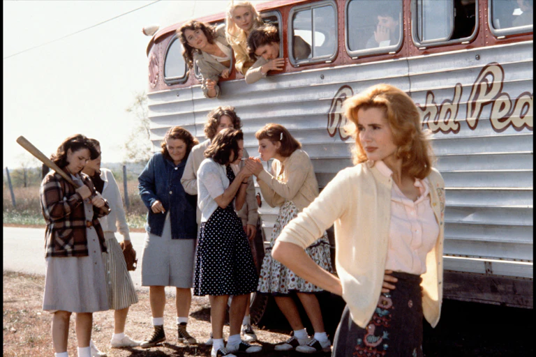 Women in 40s dress standing in front a bus