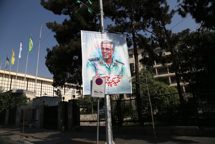 A man's image appears on a street sign poster.