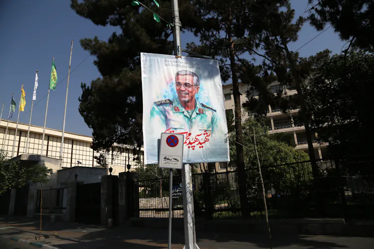 A man's image appears on a street sign poster.