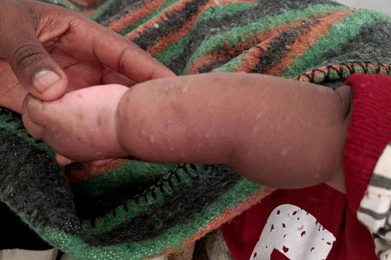 An adult holding a child's hand