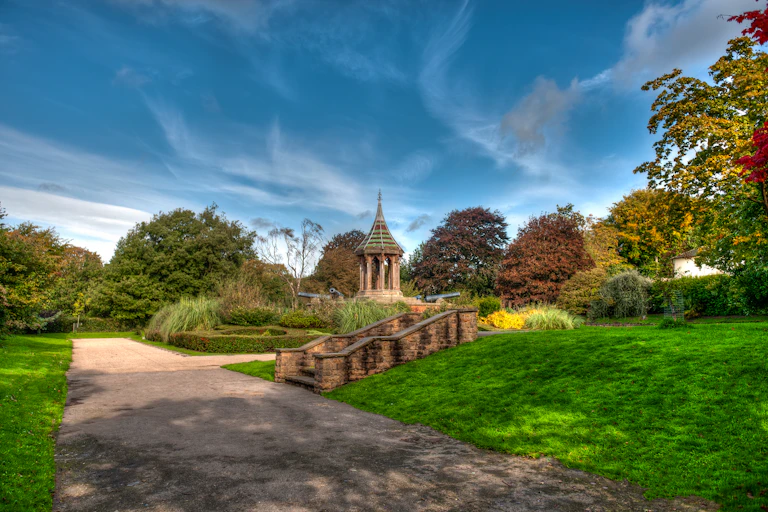 path and green park with flower beds and trees
