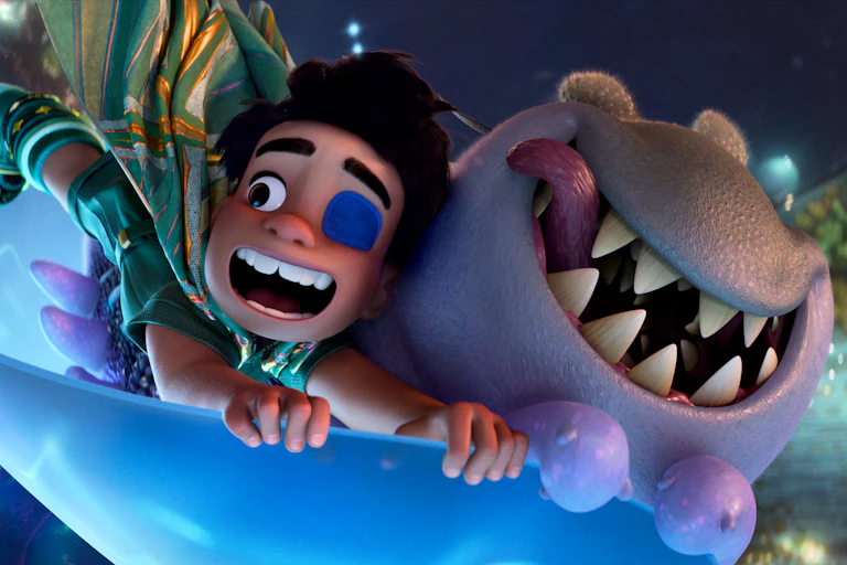 A still from the Disney animation Elio, showing a little boy flying through space with a snaggle-tooth alien pal.
